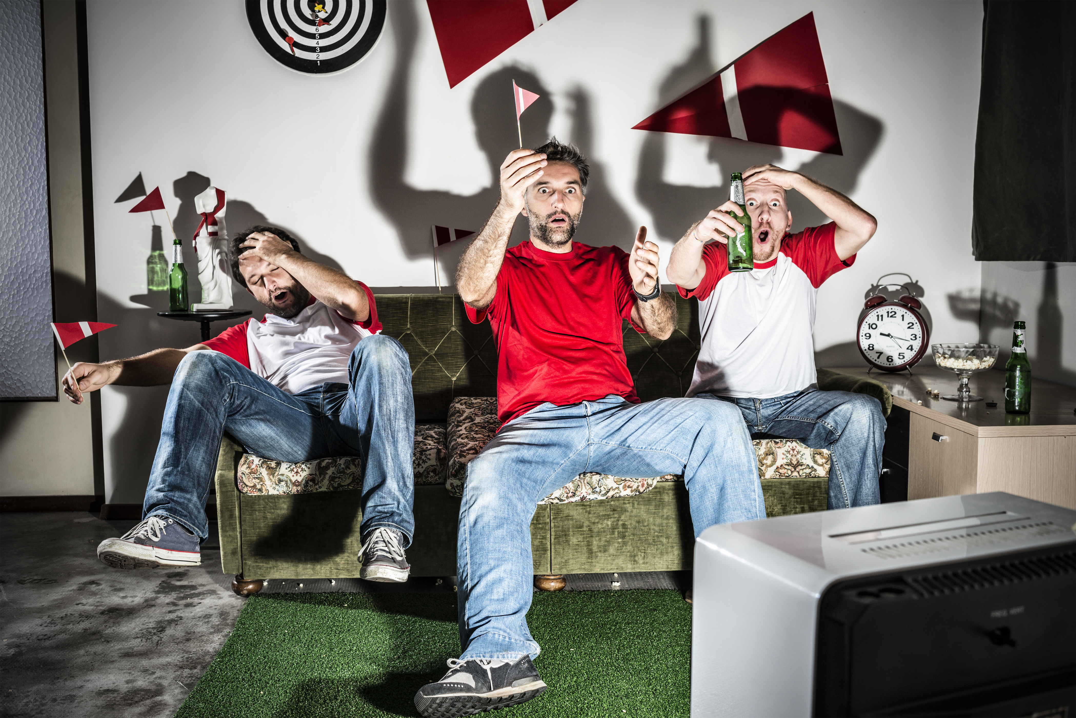 Three young adult men friends watching football: Missed goal disappointment