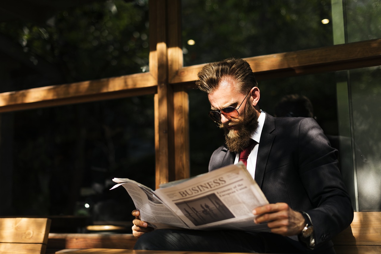 Should You Shave Your Beard for an Interview, smartly dressed man with beard reading a newspaper, bearded man, bearded in in sunglasses, man reading the newspaper, beards for business