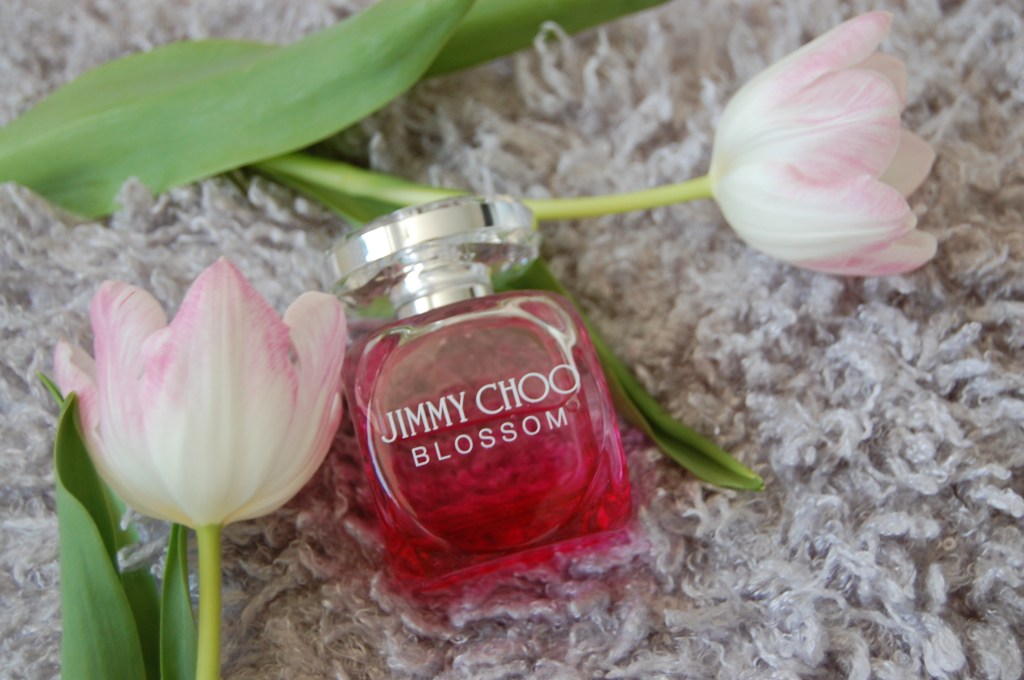 Jimmy Choo women's perfume bottle lay on a fluffy cushion with flowers for mother's day