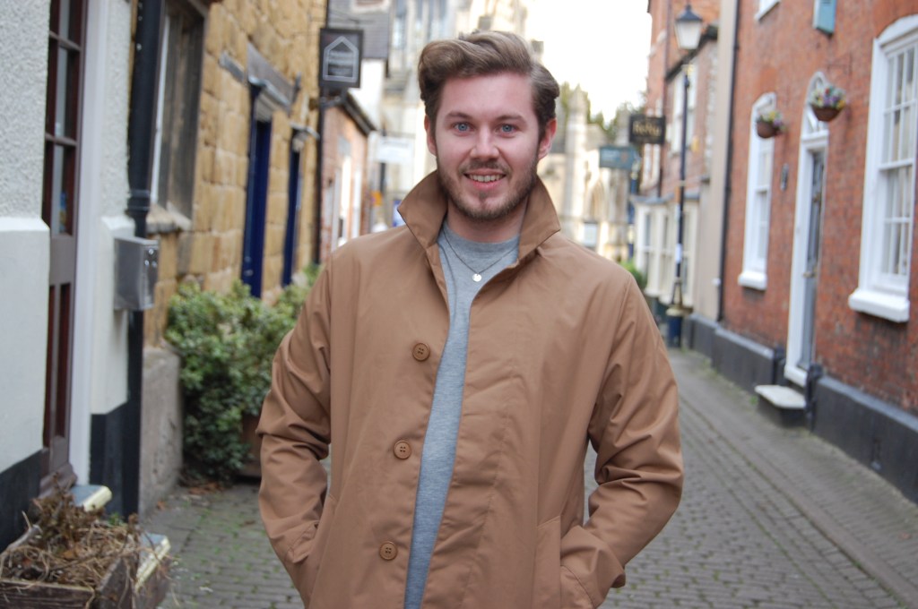 High Street Gent wearing a trendy beige coat for spring in a town street.